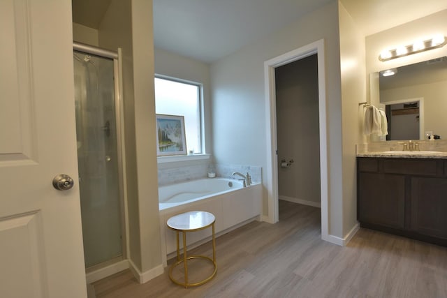 bathroom with vanity, wood-type flooring, and independent shower and bath