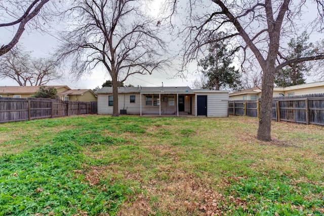 rear view of house with cooling unit and a lawn