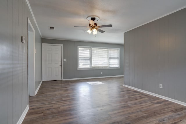 empty room featuring ornamental molding, dark hardwood / wood-style floors, and ceiling fan