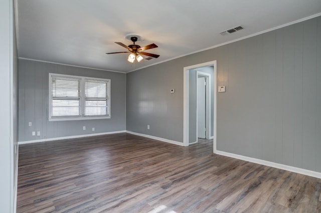 spare room featuring dark wood-type flooring, ceiling fan, and ornamental molding