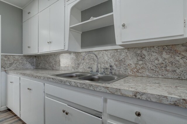 kitchen featuring backsplash, sink, and white cabinets