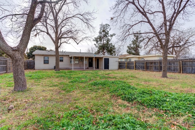 rear view of property with a yard