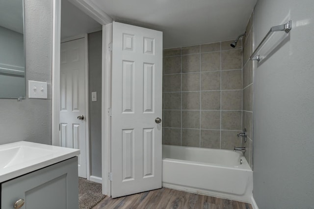 bathroom featuring vanity, hardwood / wood-style flooring, and tiled shower / bath