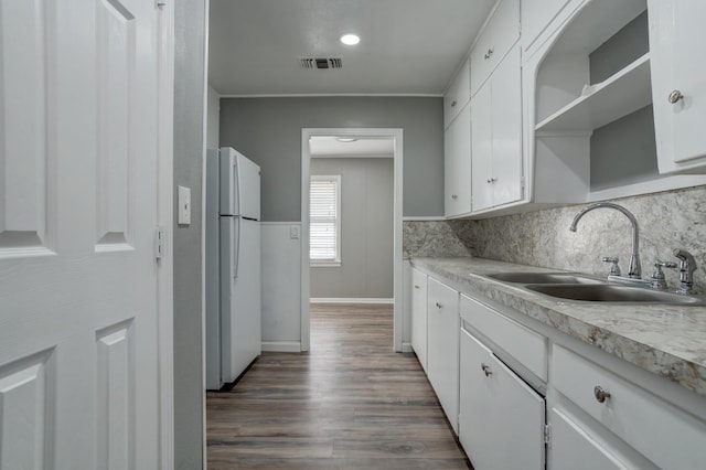 kitchen with sink, white cabinets, decorative backsplash, white fridge, and dark wood-type flooring