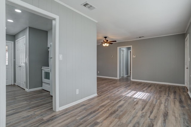 spare room with crown molding, ceiling fan, and dark wood-type flooring