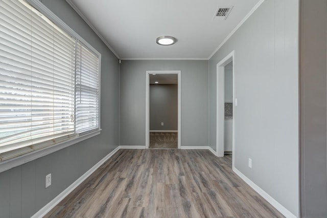 unfurnished room featuring ornamental molding and dark hardwood / wood-style flooring