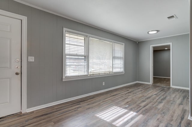 interior space with hardwood / wood-style floors and ornamental molding