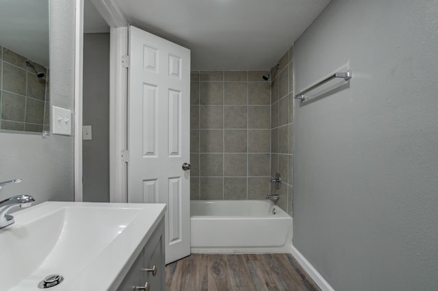 bathroom featuring vanity, wood-type flooring, and tiled shower / bath