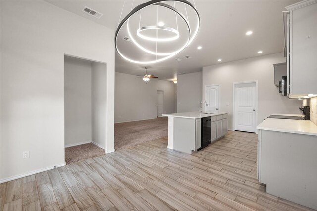 kitchen featuring pendant lighting, sink, range, ceiling fan, and light hardwood / wood-style flooring