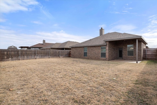 rear view of property featuring a yard and a patio