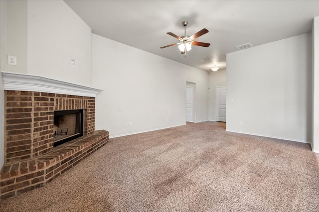 unfurnished living room featuring a brick fireplace, carpet floors, and ceiling fan