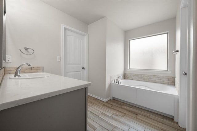 bathroom featuring hardwood / wood-style flooring, vanity, and a bathtub