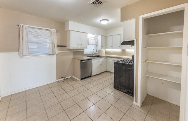 kitchen featuring dishwasher, sink, white cabinets, range, and light tile patterned floors