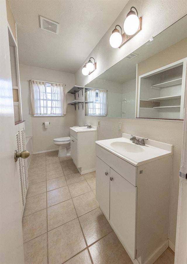 bathroom featuring vanity, tile patterned floors, and toilet