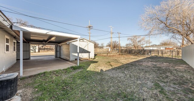 view of yard with central air condition unit and a storage unit