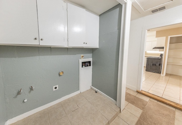 clothes washing area featuring gas dryer hookup, electric dryer hookup, hookup for a washing machine, cabinets, and light tile patterned flooring