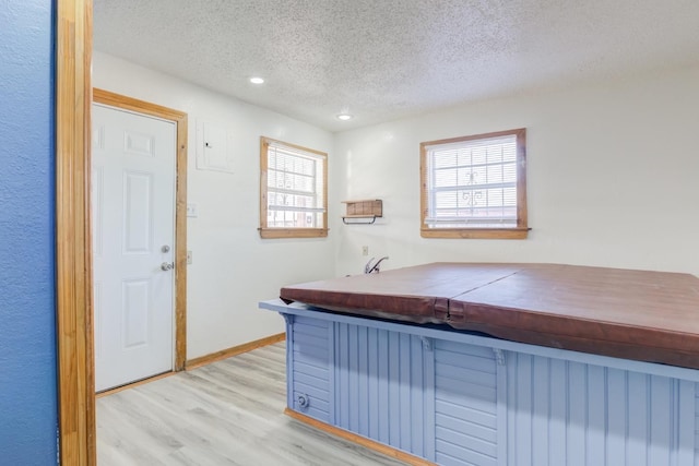 interior space featuring a textured ceiling and light wood-type flooring