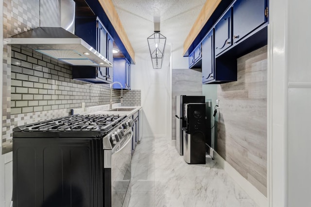 kitchen featuring sink, blue cabinetry, stainless steel gas stove, a textured ceiling, and wall chimney exhaust hood