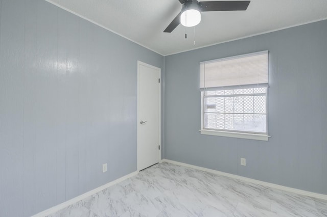 empty room featuring ornamental molding and ceiling fan