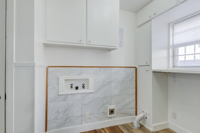 washroom with cabinets, washer hookup, wood-type flooring, and electric dryer hookup