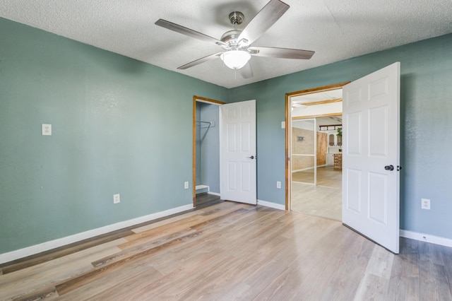 unfurnished bedroom with ceiling fan, a closet, a textured ceiling, and light wood-type flooring