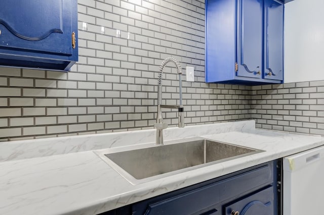 kitchen with sink, backsplash, dishwasher, and blue cabinets