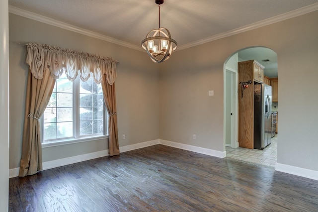 spare room with ornamental molding, dark hardwood / wood-style floors, and a notable chandelier