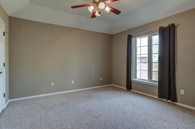 spare room featuring a tray ceiling, carpet floors, and ceiling fan