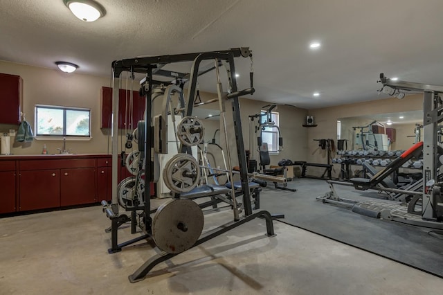 gym featuring sink and a textured ceiling