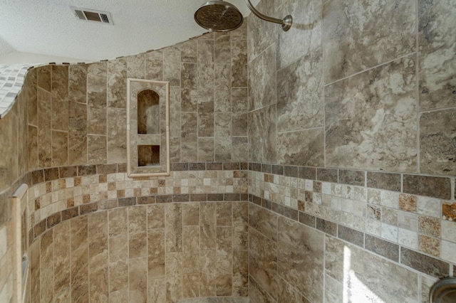 details with a textured ceiling and a tile shower