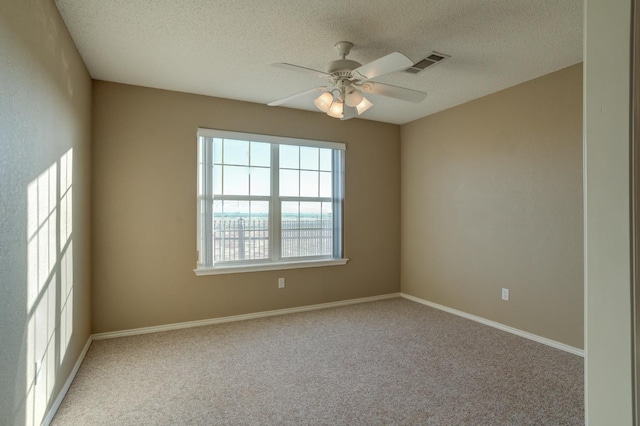 carpeted empty room featuring ceiling fan and a textured ceiling