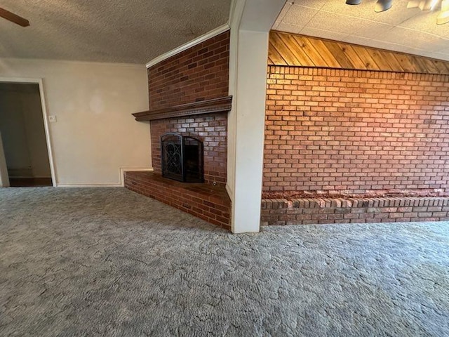 unfurnished living room featuring brick wall, a brick fireplace, carpet flooring, and a textured ceiling