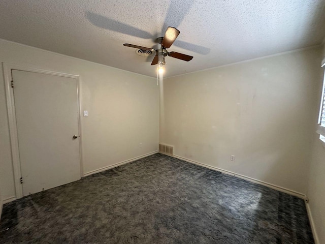 carpeted spare room with ceiling fan and a textured ceiling