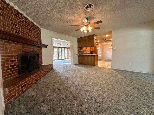 unfurnished living room featuring ceiling fan, light carpet, a textured ceiling, and a fireplace