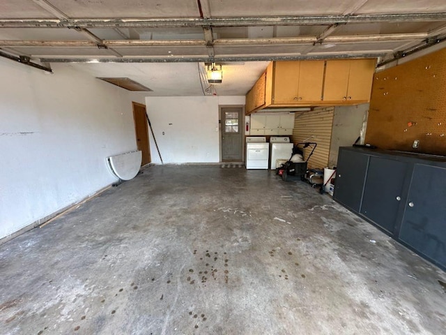 garage with a garage door opener and independent washer and dryer