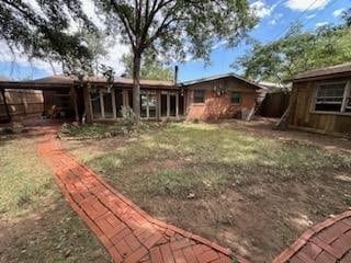 rear view of property with a lawn