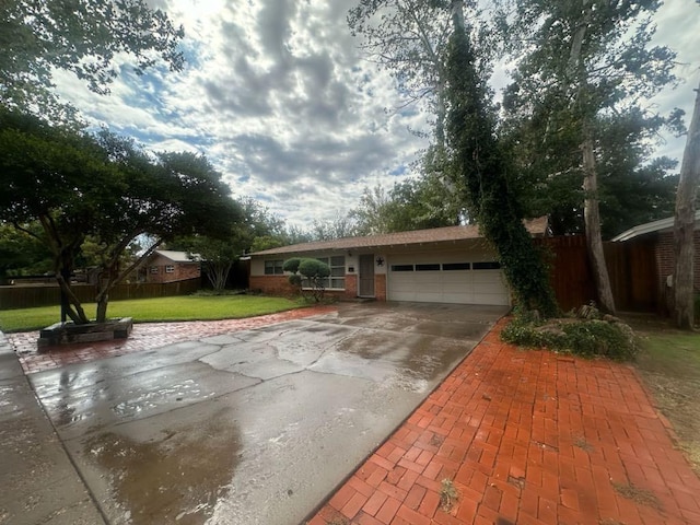 single story home featuring a garage and a front yard