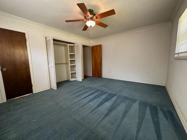 unfurnished bedroom with dark colored carpet, ornamental molding, ceiling fan, and a textured ceiling