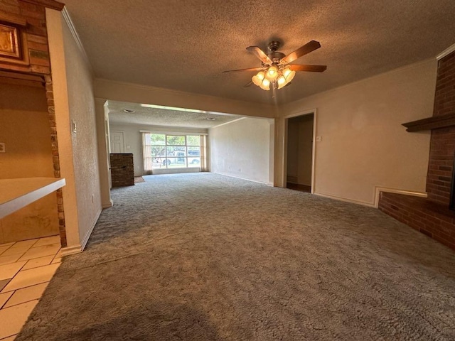 unfurnished living room featuring carpet floors, ornamental molding, ceiling fan, a brick fireplace, and a textured ceiling