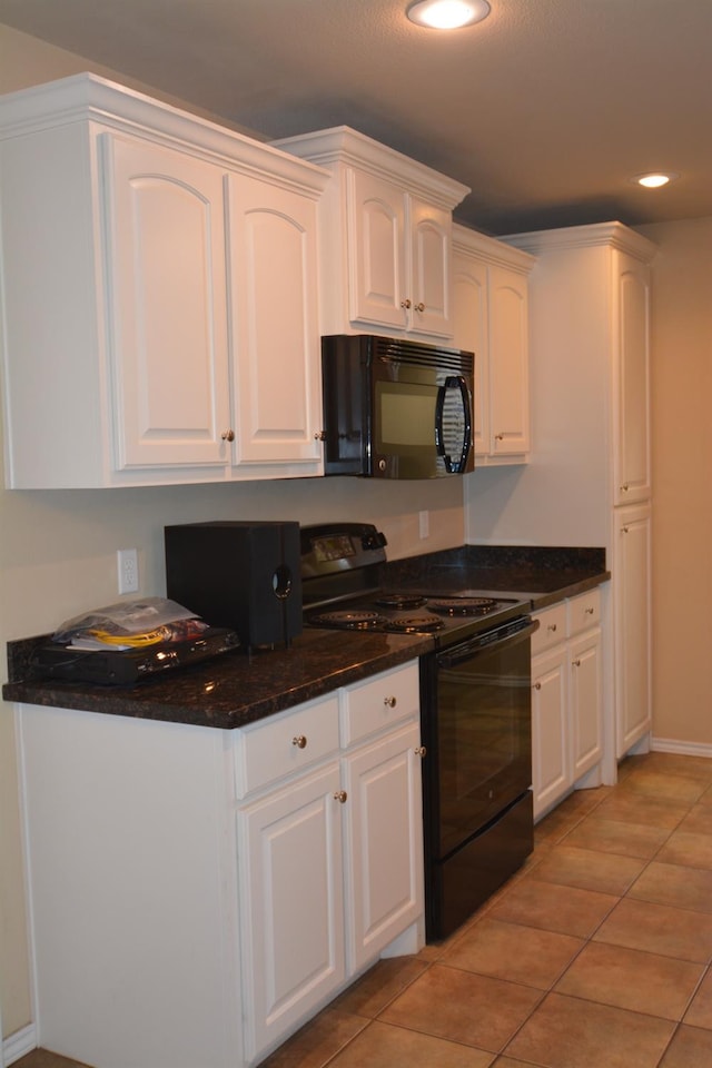 kitchen featuring light tile patterned floors, white cabinets, dark stone counters, and black appliances