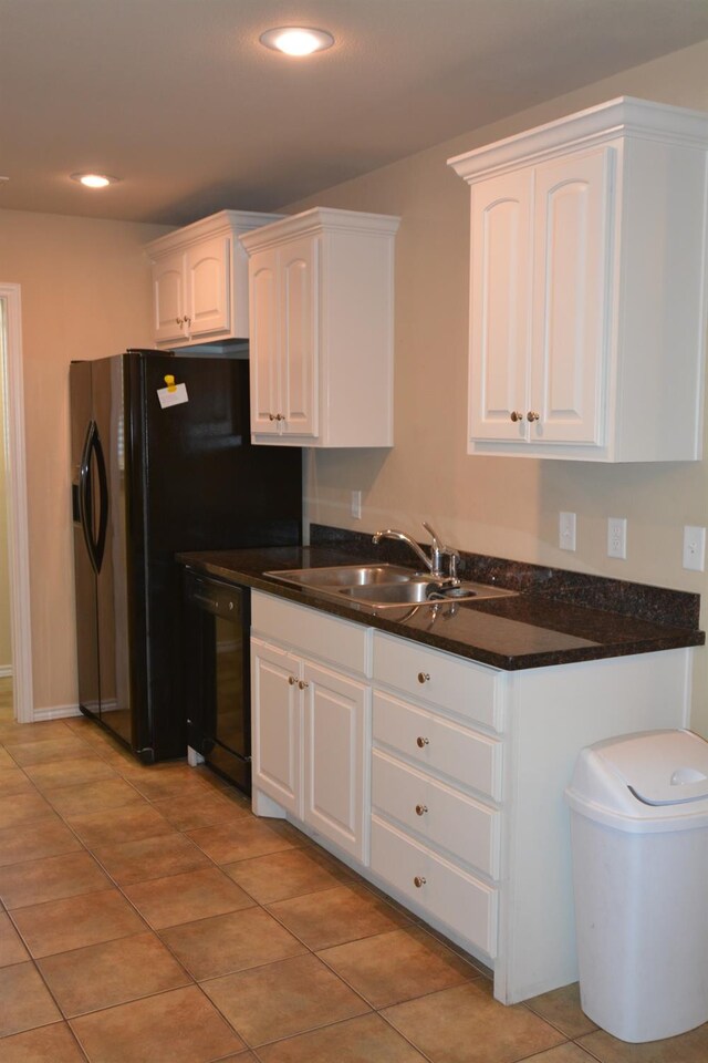 kitchen featuring white cabinetry, black dishwasher, sink, and light tile patterned floors