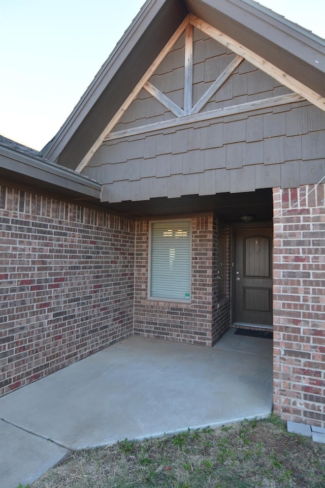 exterior entry at dusk featuring a patio