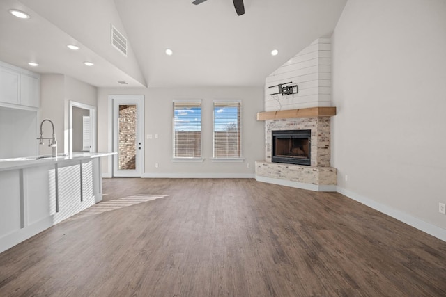 unfurnished living room with hardwood / wood-style flooring, ceiling fan, high vaulted ceiling, and sink