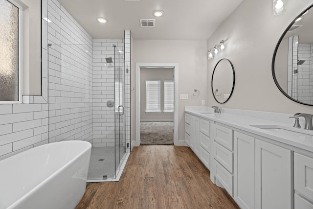 bathroom with hardwood / wood-style flooring, vanity, and separate shower and tub