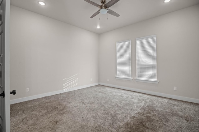 carpeted spare room featuring ceiling fan