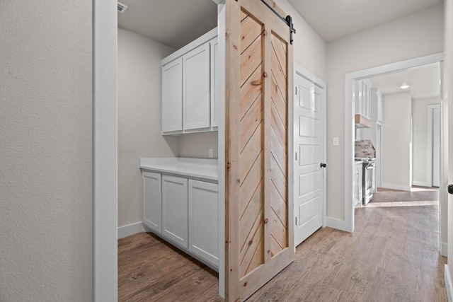 corridor featuring a barn door and light wood-type flooring