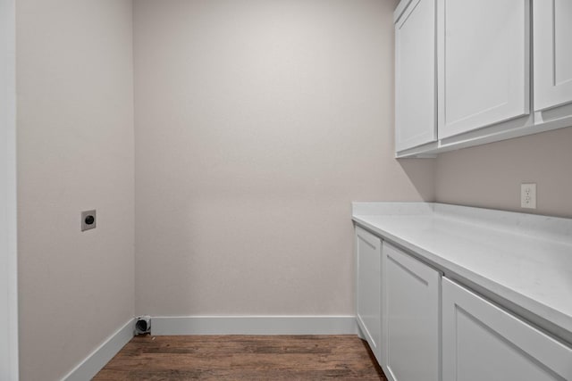 laundry area with dark wood-type flooring, cabinets, and hookup for an electric dryer