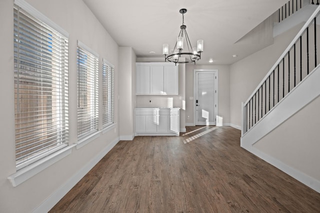 foyer with dark wood-type flooring and a chandelier