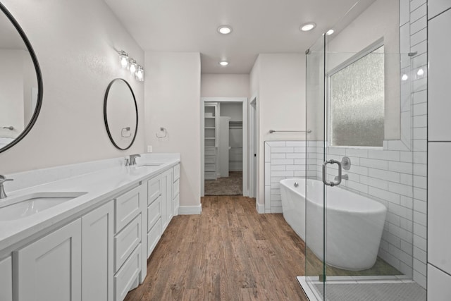 bathroom featuring hardwood / wood-style flooring, vanity, separate shower and tub, and tile walls