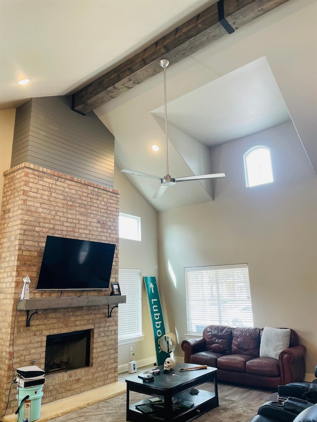 living room featuring a brick fireplace, beam ceiling, and high vaulted ceiling